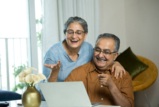 istock Old couple having fun using laptop at home 1336515490