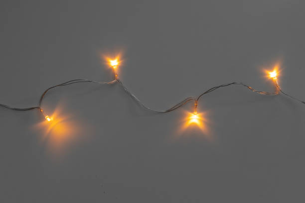 istock Glowing golden electric garland on a gray background 1336515519