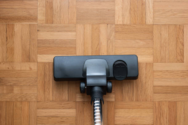 Vacuum cleaner attachment on wooden floor tiles inside room, no people, top view stock photo