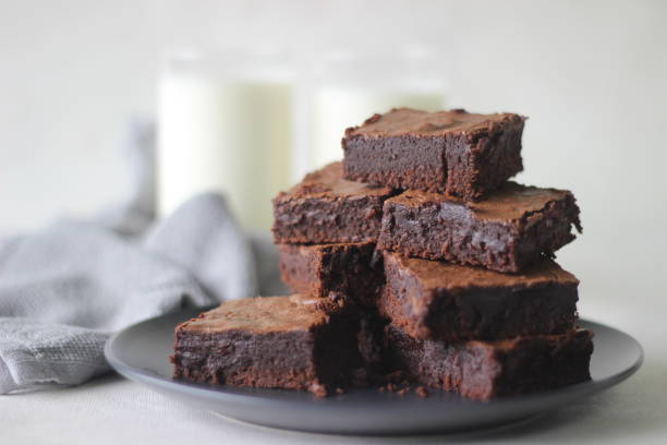 hausgemachter fudgy schokoladen-brownie in quadratische blöcke geschnitten und übereinander gestapelt - brownie baked bakery brown stock-fotos und bilder