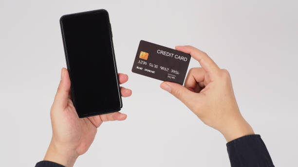 istock Hand is holding smart phone and black credit card on white background. 1336517838
