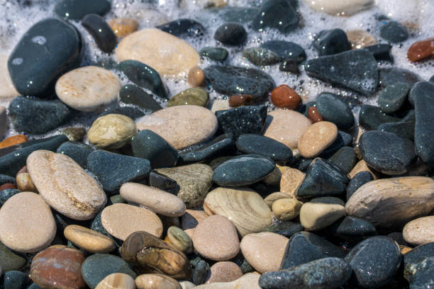 istock Close-up of wet pebbles on sea beach 1336521420