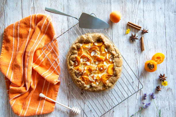 Apricot galette pie cake placed on wooden background with cooking tools on the side Apricot galette pie cake placed on wooden background with cooking tools on the side czech republic photos stock pictures, royalty-free photos & images