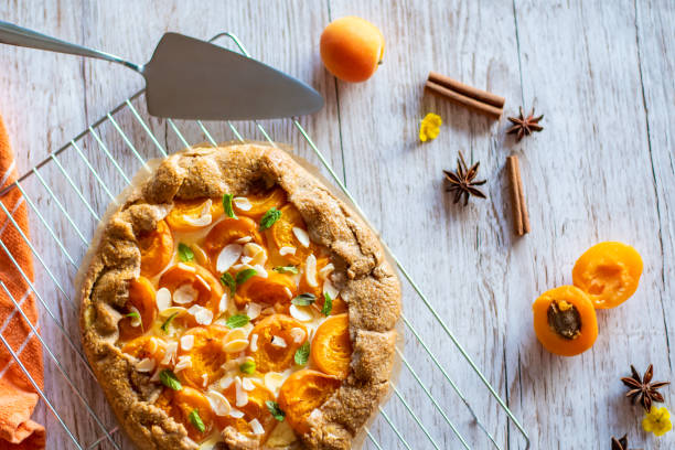 gâteau à tarte à la galette d’abricot placé sur fond en bois avec des outils de cuisson sur le côté - pie fruit cobbler sweet food photos et images de collection