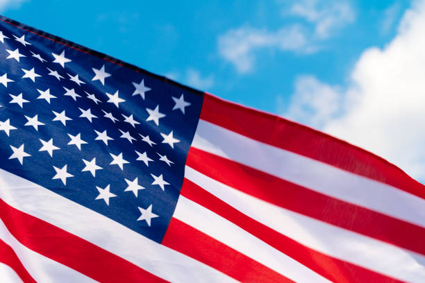istock American flag waving in the wind against blue sky 1336524306