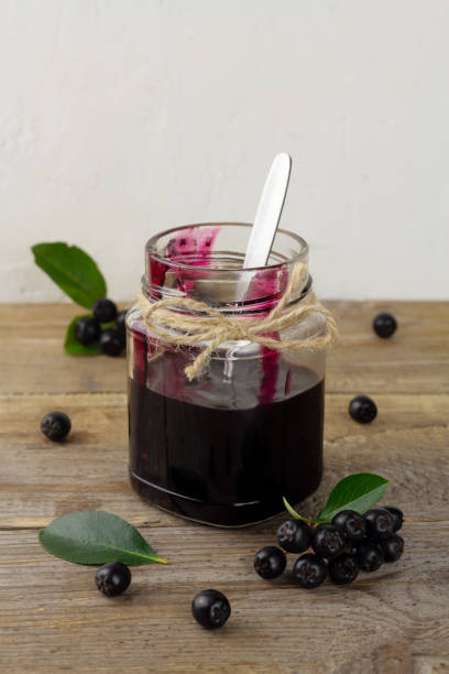 istock Chokeberry jam and fresh berries on wooden table 1336528454