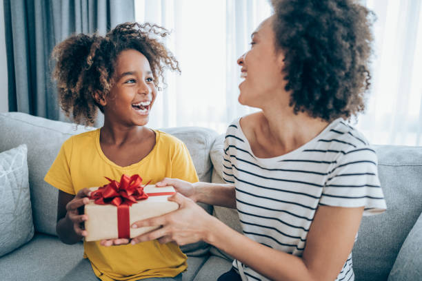 wesołe dziecko otrzymujące prezent od mamy. - gift mothers day birthday giving zdjęcia i obrazy z banku zdjęć