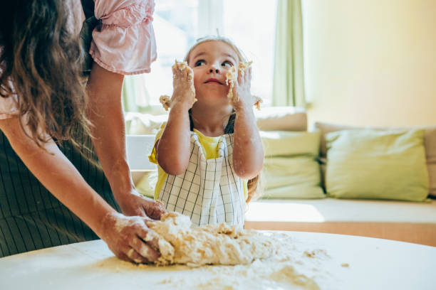 istock Mother and daughter preparing dough. 1336531057