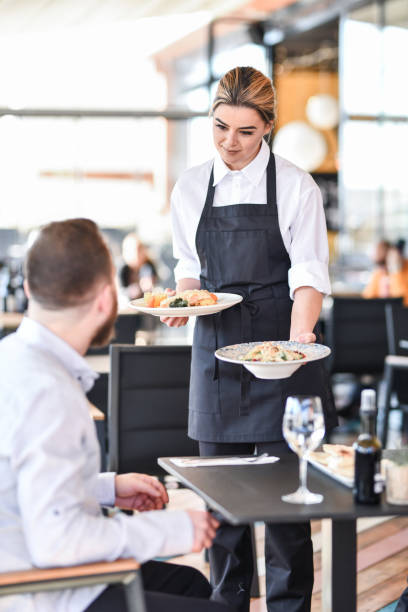 istock Waitress Bringing Special Food For Customers In Restaurant 1336533201