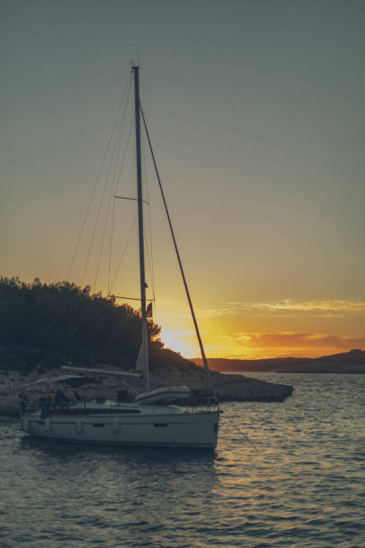 istock Sailboat and rugged coastline at sunset 1336537042