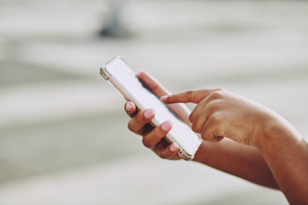 istock Cropped shot of an unrecognisable woman using her cellphone while standing outside 1336539412