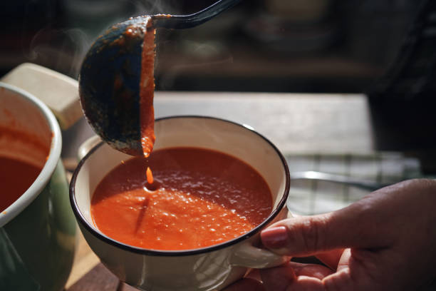 zubereitung von cremiger tomatensuppe - tomatensuppe stock-fotos und bilder