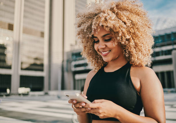 istock Shot of a young woman using her cellphone while standing outside 1336539445