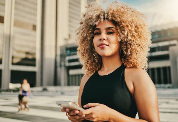 istock Shot of a young woman using her cellphone while standing outside 1336539449
