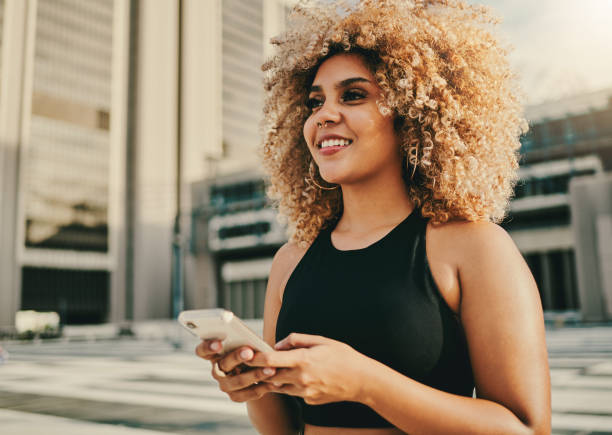 istock Shot of a young woman using her cellphone while standing outside 1336539451