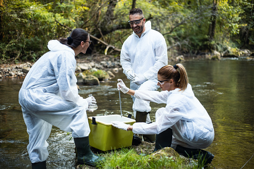 Young scientists take water samples from the mountain river