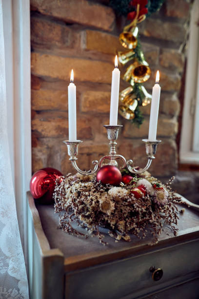 istock Christmas wreath and white burning candles at home. 1336546108