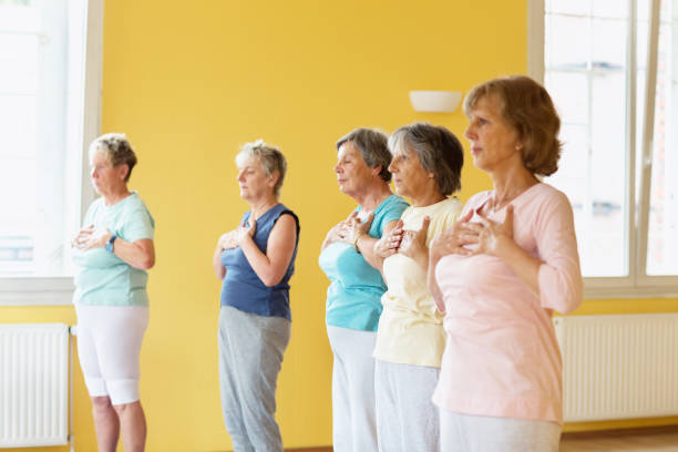 istock breathing exercise in yoga class with senior adults: hands on chest 1336546688