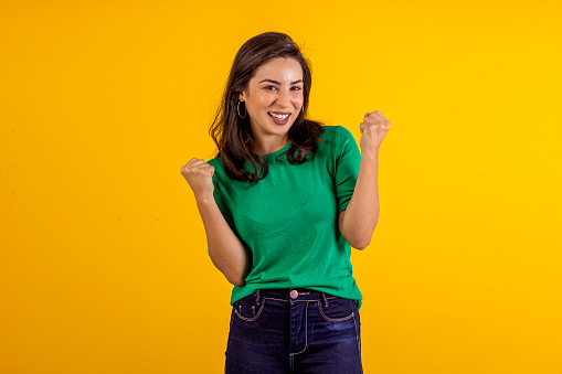 Studio shot of young woman in blue shirt on yellow background with various facial expressions.