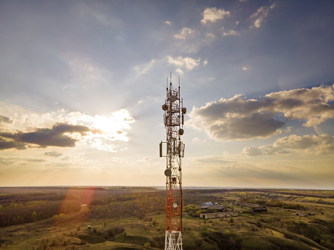 Antenna with 5G technology in rural countryside at sunset. Telecom tower with 5G and 4G network, telecommunication base station