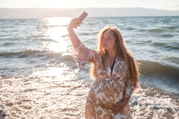 istock Beautiful plus size model woman making selfie at the beach 1336547730