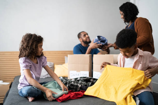 istock Parents with children sorting out clothes in boxes to donate at home 1336548488