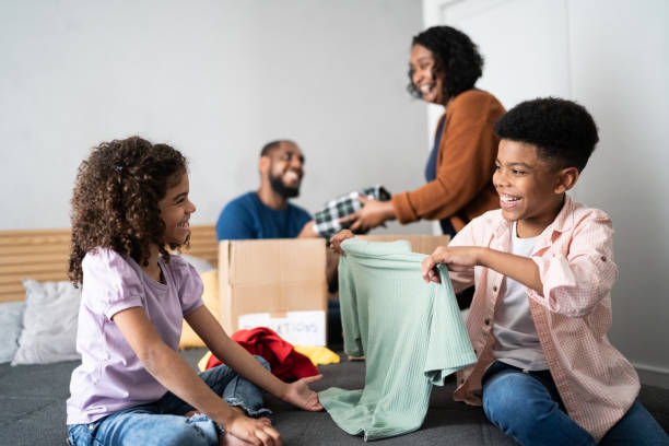 istock Parents with children sorting out clothes in boxes to donate at home 1336548504