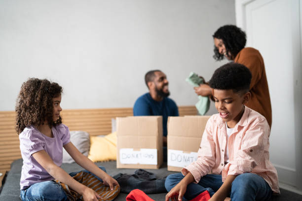 istock Parents with children sorting out clothes in boxes to donate at home 1336548511