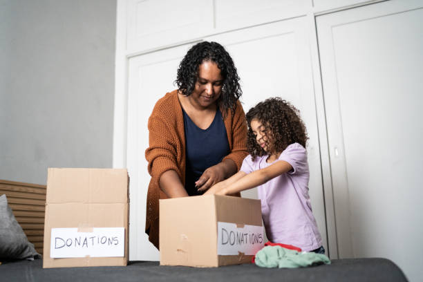 istock Mother and daughter sorting out clothes in boxes to donate at home 1336548538