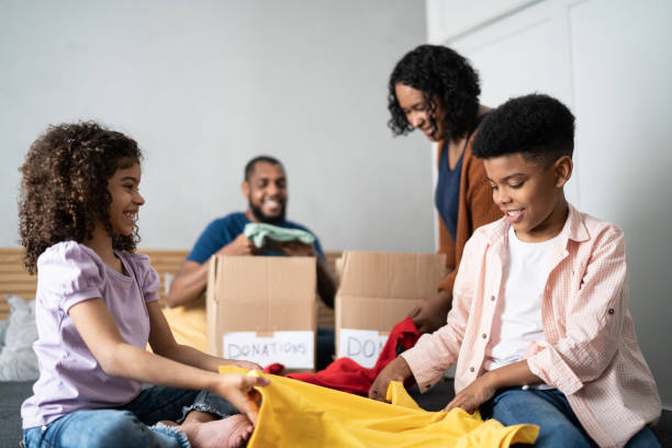 istock Parents with children sorting out clothes in boxes to donate at home 1336548546