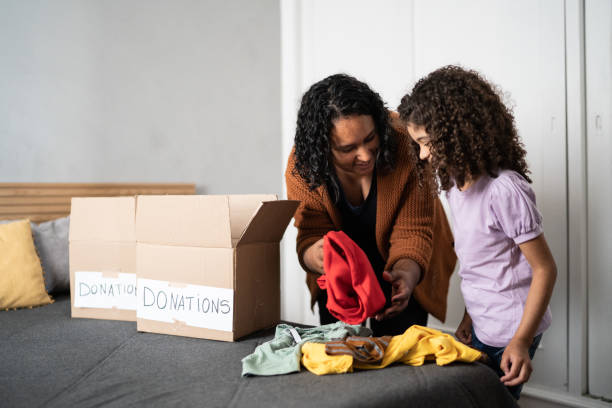 istock Mother and daughter sorting out clothes in boxes to donate at home 1336548553
