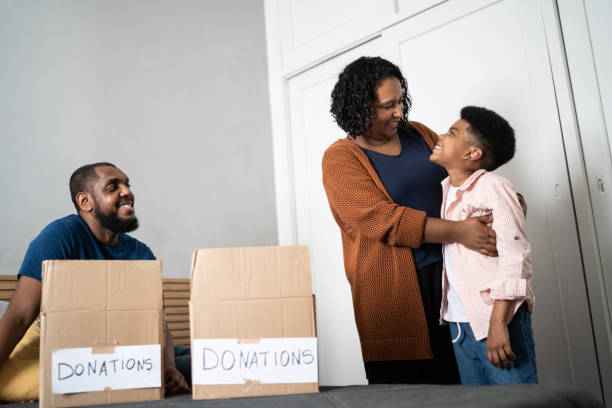 istock Parents with son sorting out clothes in boxes to donate at home 1336548563