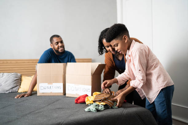 istock Parents with son sorting out clothes in boxes to donate at home 1336548567
