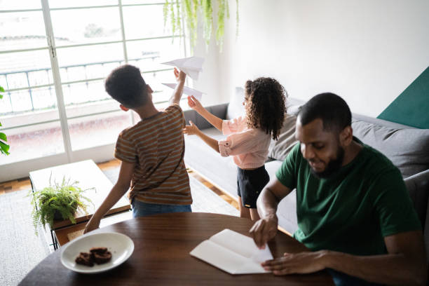 istock Father doing paper airplane and siblings playing with it at home 1336548941