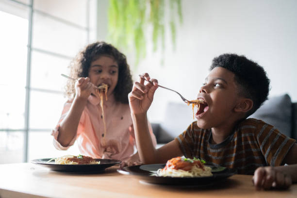 istock Siblings at table eating at home 1336549922
