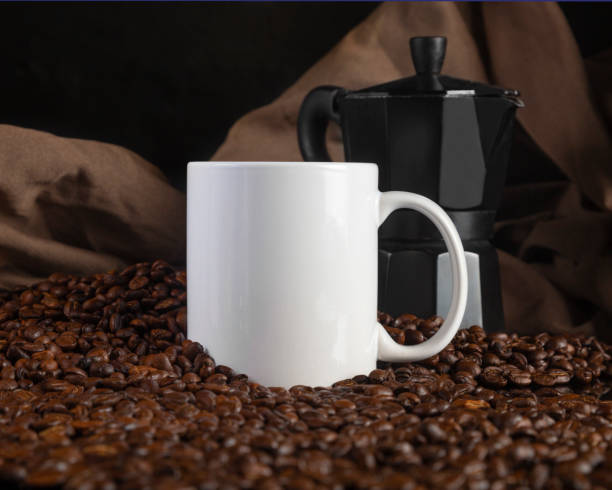 istock 11 oz White Glossy Mug Mockup with coffee beans on dark background 1336552471