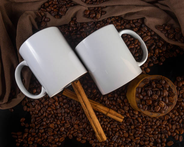 istock 11 oz White Glossy Mugs Mockup with coffee beans on dark background 1336552482