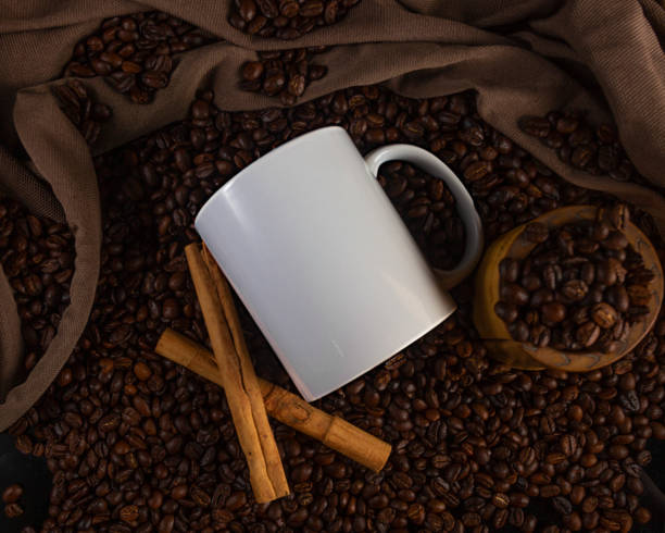 istock 11 oz White Glossy Mug Mockup with coffee beans on dark background 1336552484