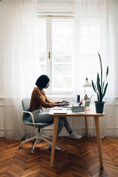 istock Cheerful Business Woman Working from Home on Laptop Computer 1336556411