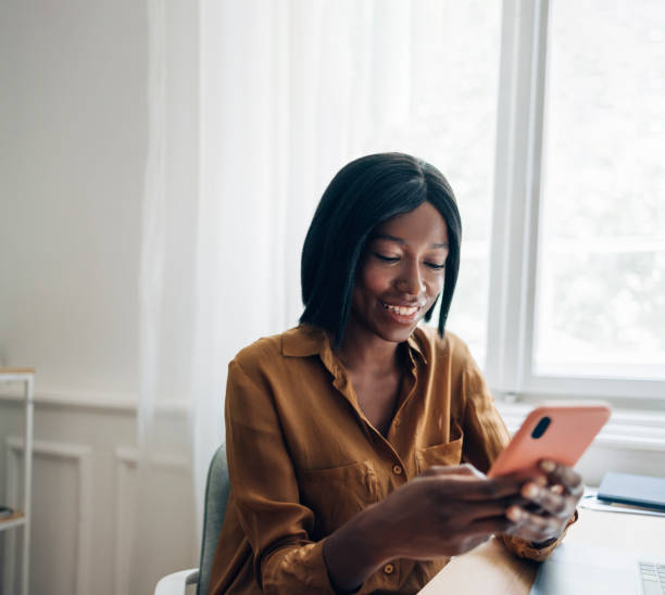 istock Cheerful Business Woman Using Mobile Phone at Home 1336556455