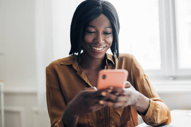 istock Cheerful Business Woman Using Mobile Phone at Home 1336556461