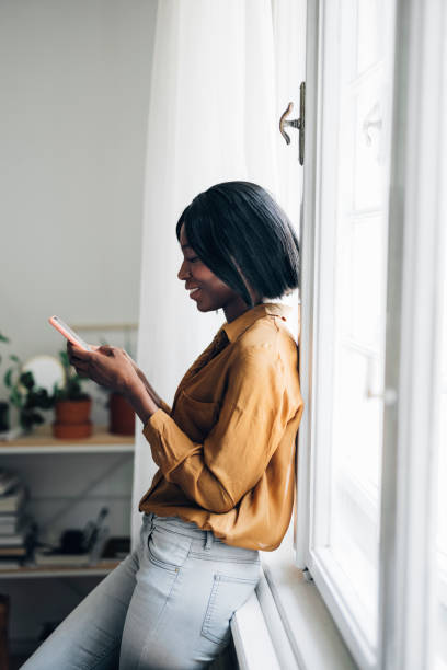istock Cheerful Business Woman Using Mobile Phone at Home 1336556469
