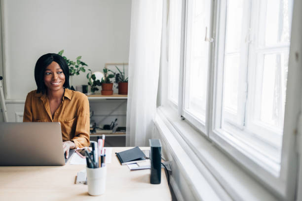 istock Cheerful Business Woman Working from Home on Laptop Computer 1336556474