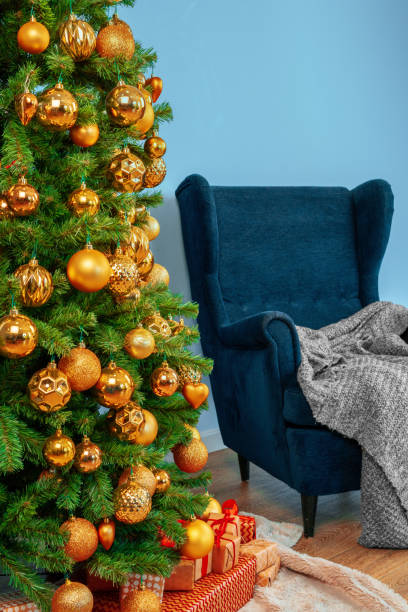 istock Holiday interior. Beautiful decorated christmas tree with blue armchair 1336559243