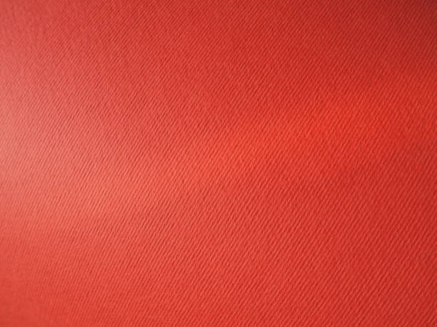 istock Abstract red background with texture. Close-up of paper surface with light and color gradient. Side lighting. Bright crimson backdrop 1336568768