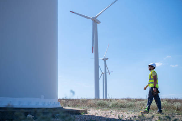 istock Technician walking to the base of a wind turbine with digital tablet 1336569276