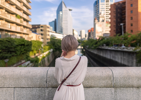 One Japanese woman walking in cities in Tokyo at sunset time and night.