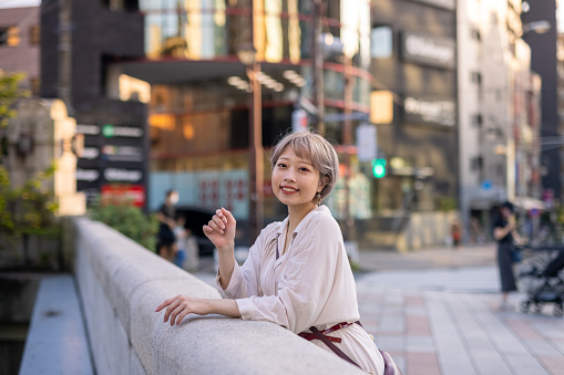 One Japanese woman walking in cities in Tokyo at sunset time and night.