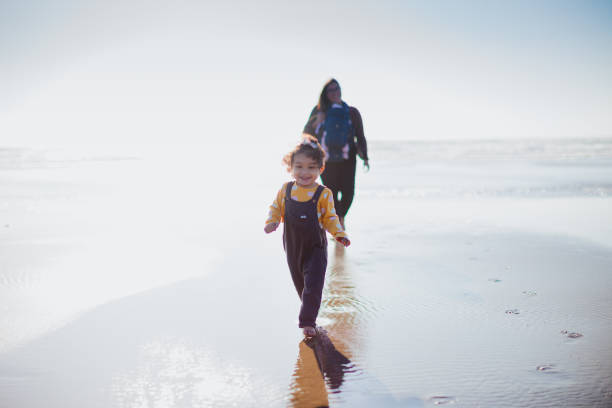 istock Family Walking on the Beach Together 1336570309