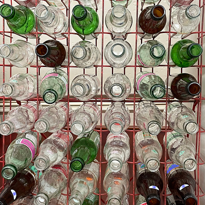 Empty soda bottles in a forward facing rack are waiting for deposit return at old fashioned soda shop in Mt. Airy NC